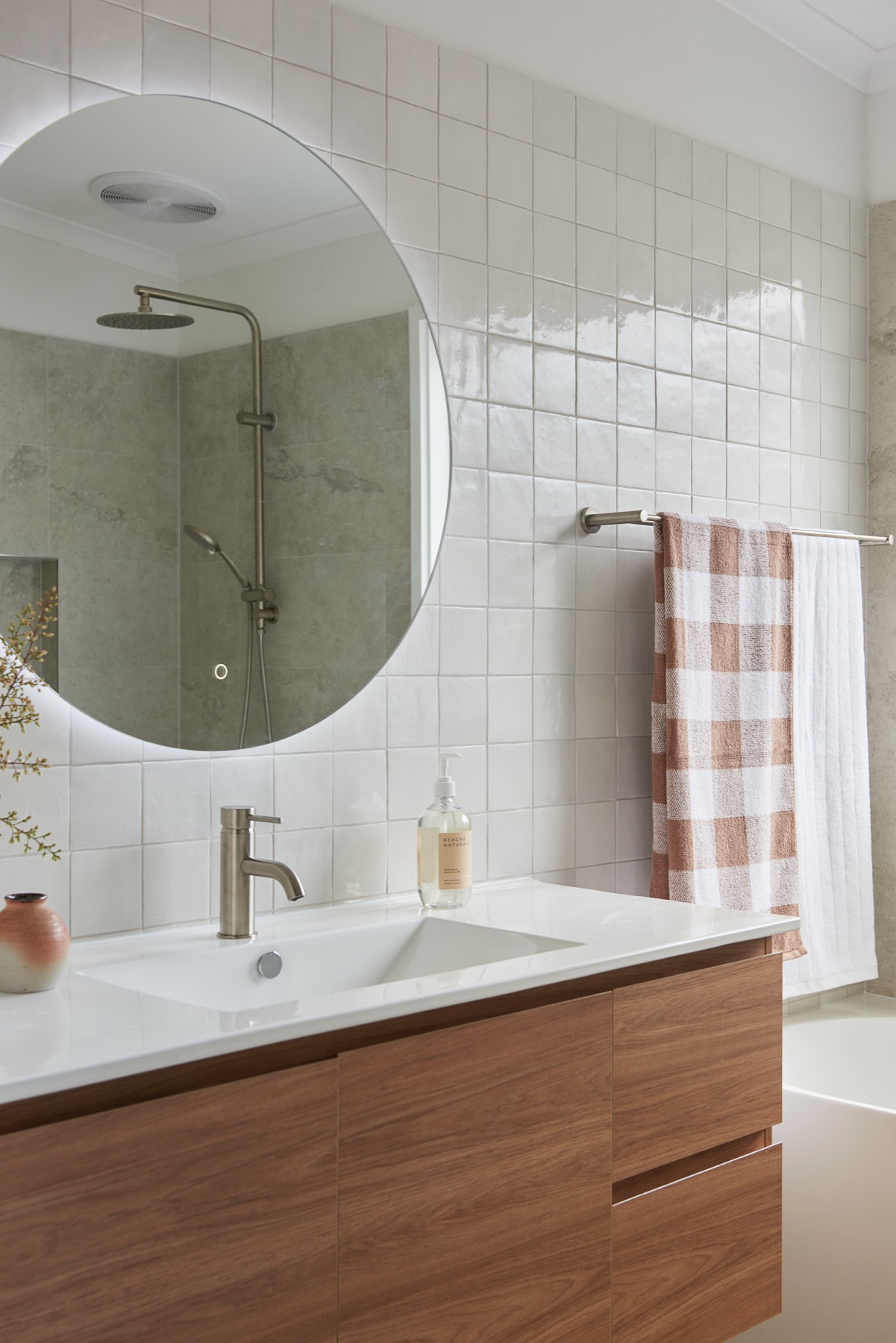 Timber vanity with round backlit mirror and square tiles