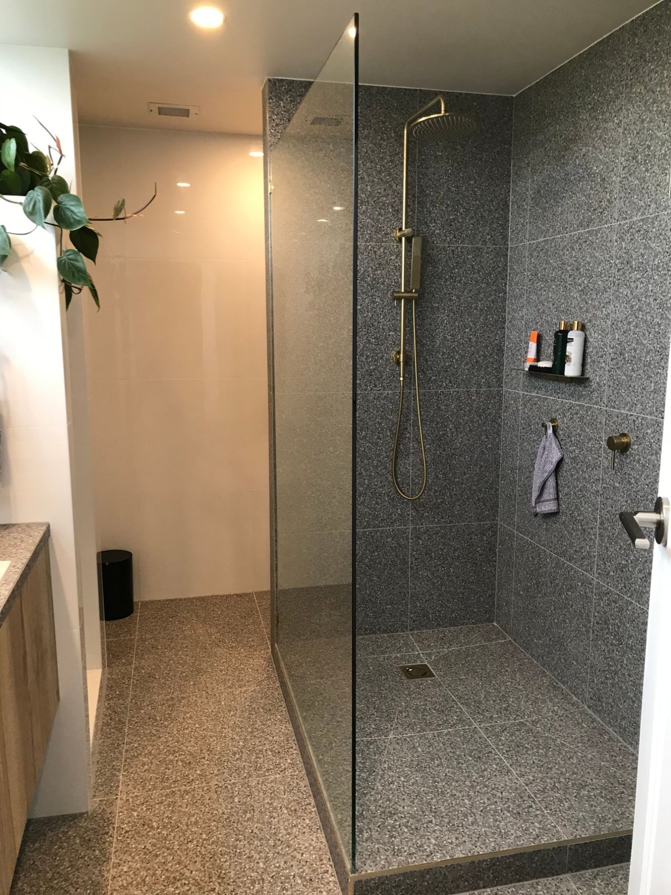 Terrazzo walk-in shower with brushed brass fittings